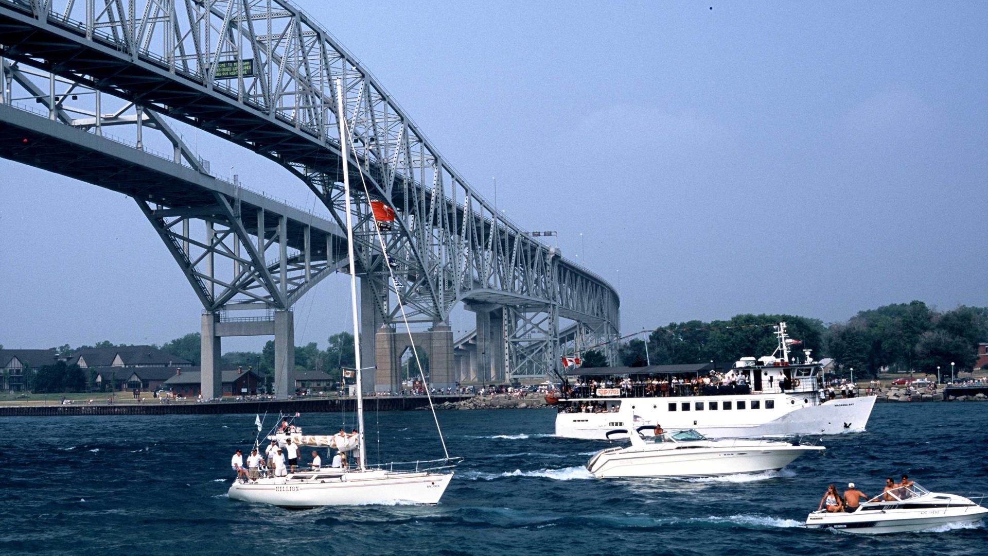 Boats sailing under bridge.