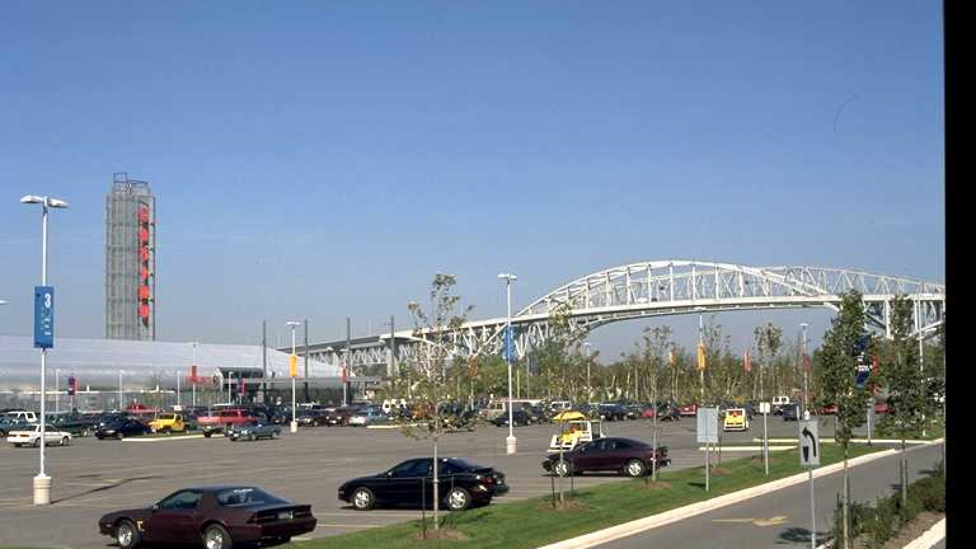 Parking lot in the foreground. A white bridge stands tall in the background.