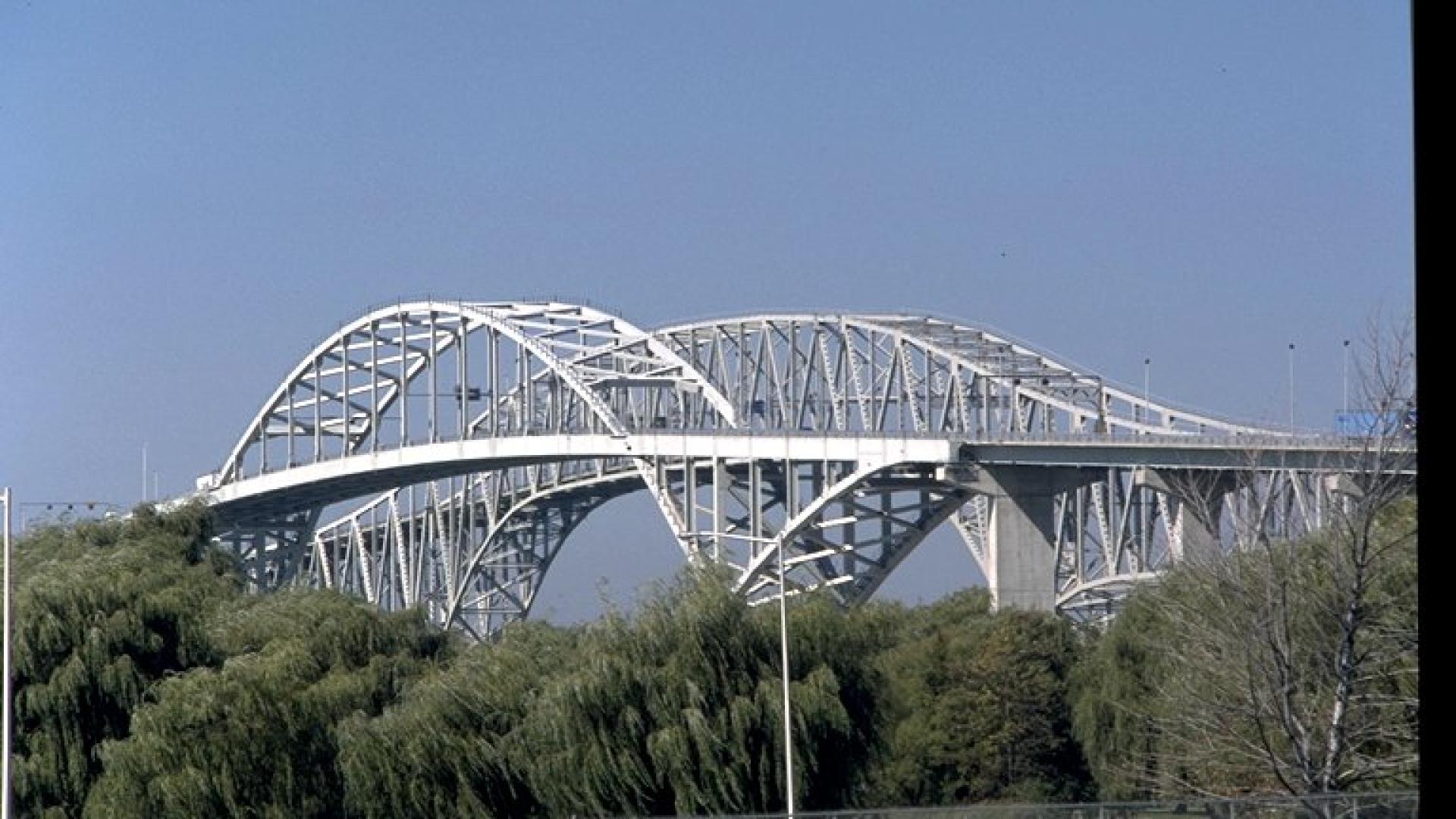 Landscape of bridge with blue sky in the background.