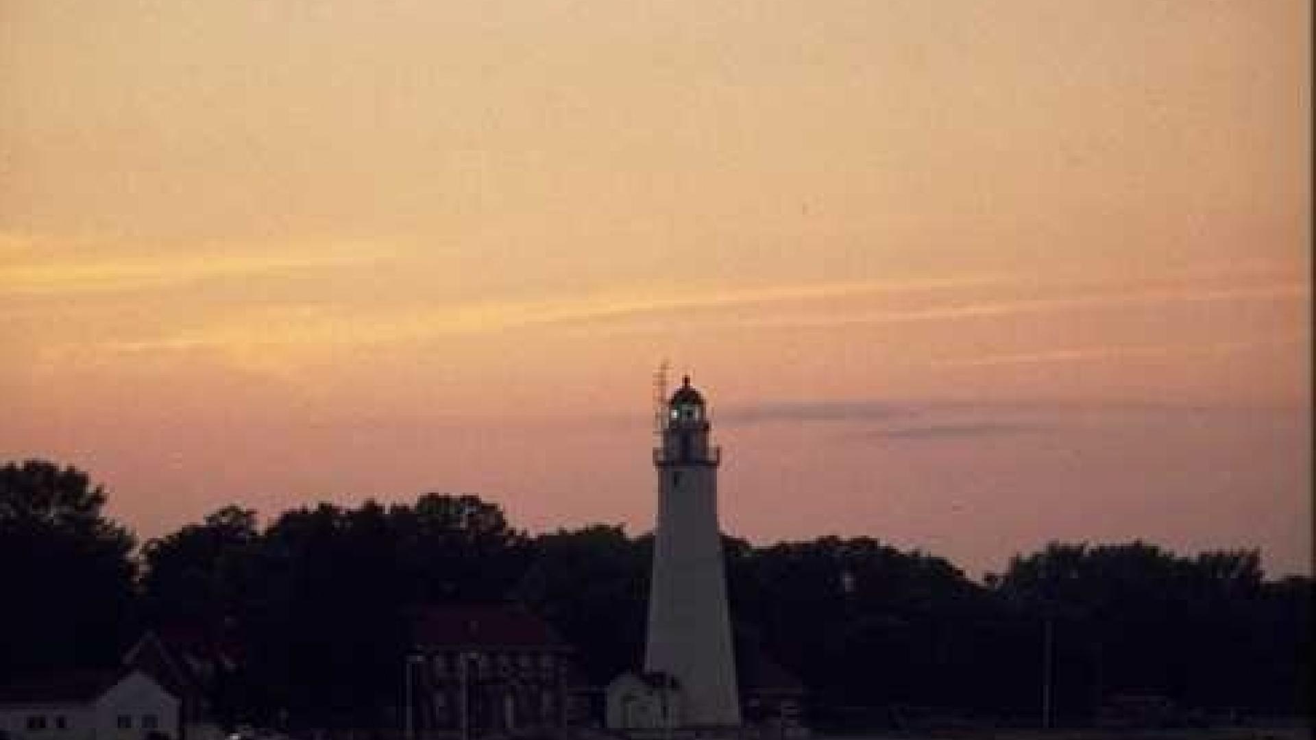 Lighthouse with orange background sky. 