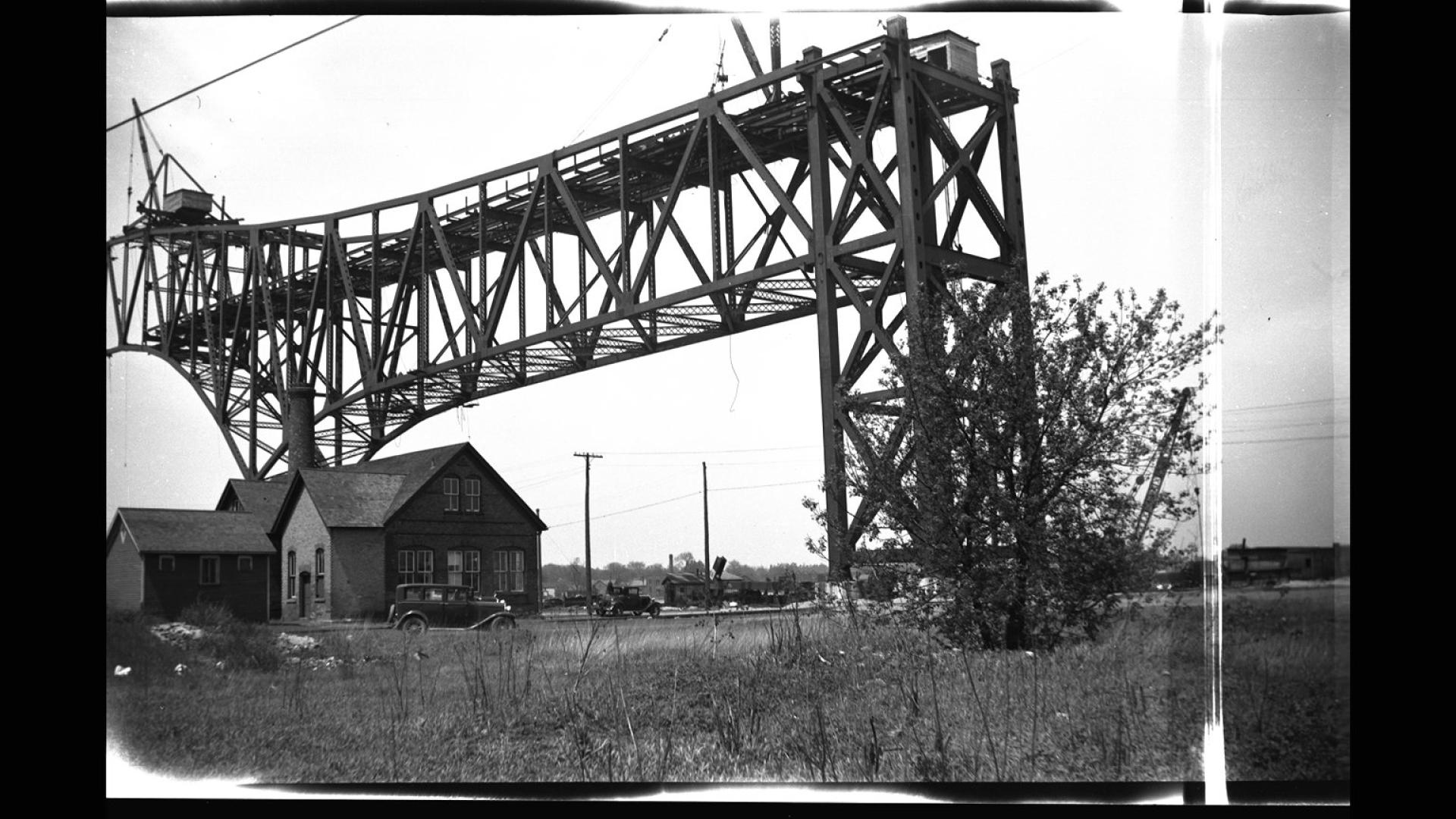 Section of bridge being built next to a house.