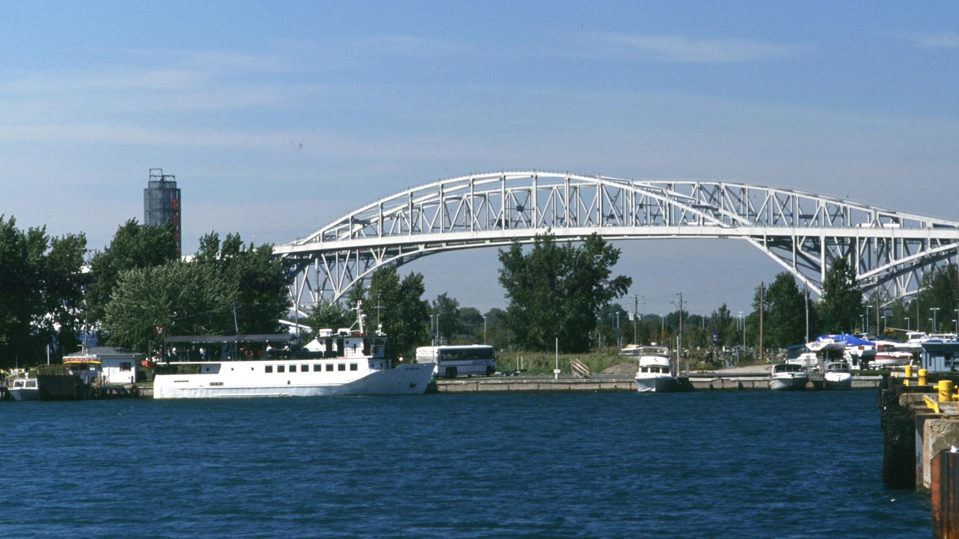 Boats sailing in the foreground. The bridge stand tall in the background.