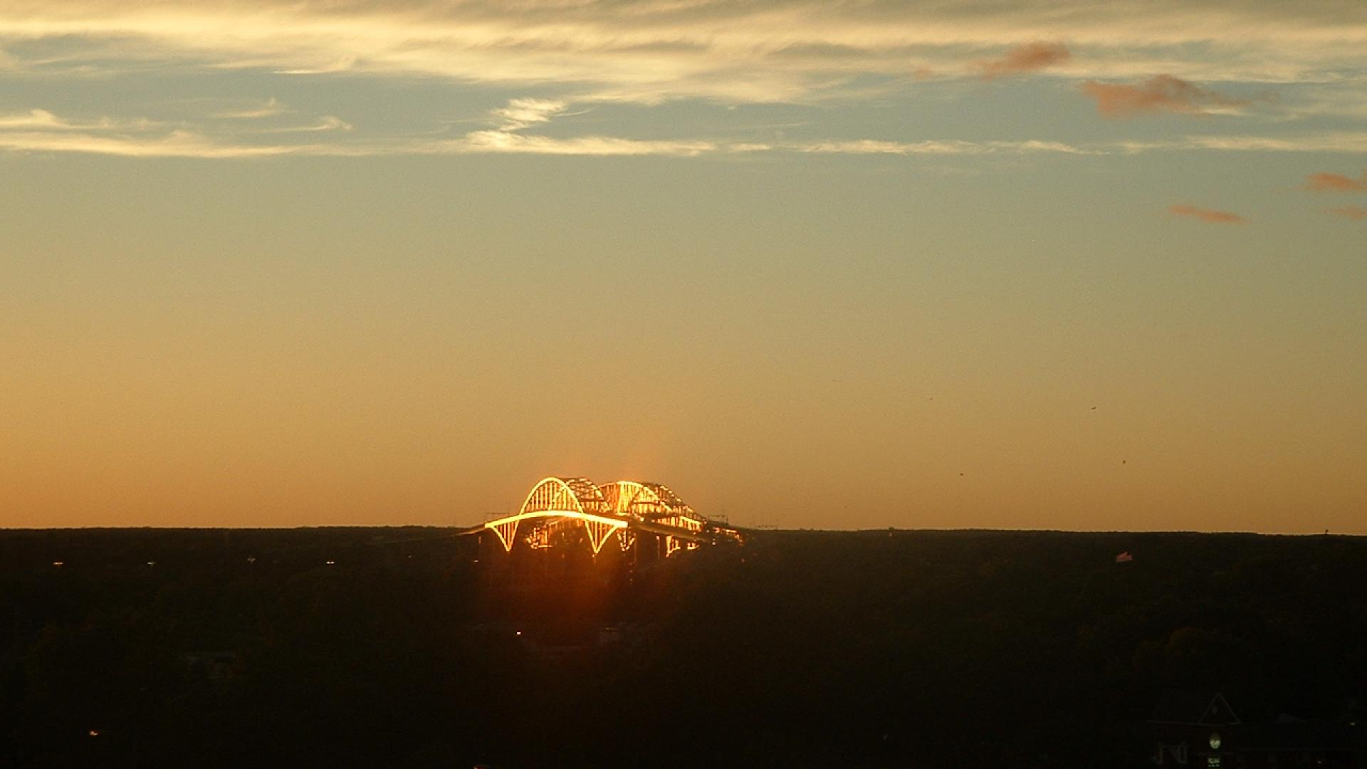 Landscape of orange sky. The bridge is glowing in a bright copper colour.