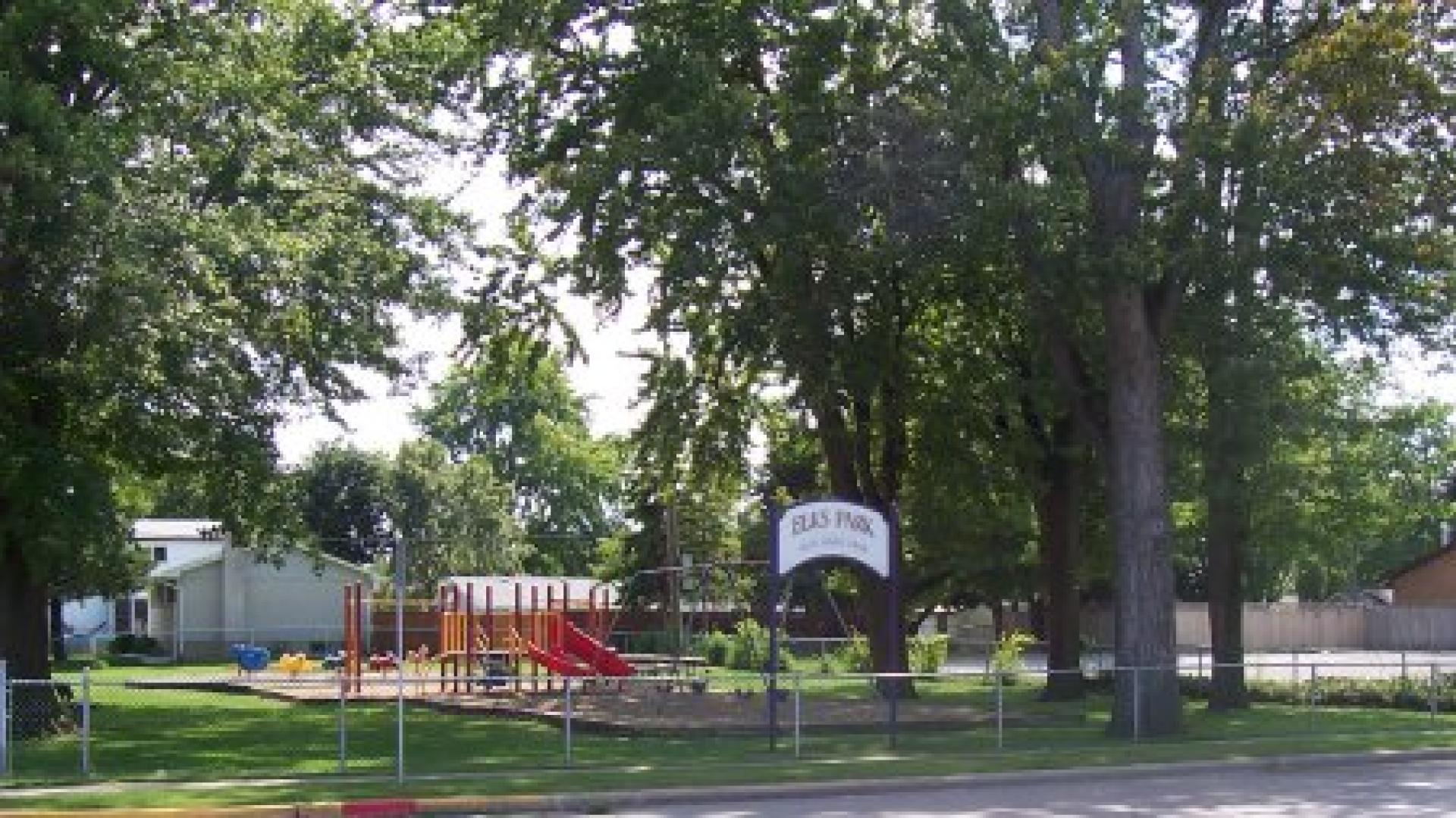Small playground. There is signage by the entrance with the park's name on it. The playground consists of a red jungle gym.